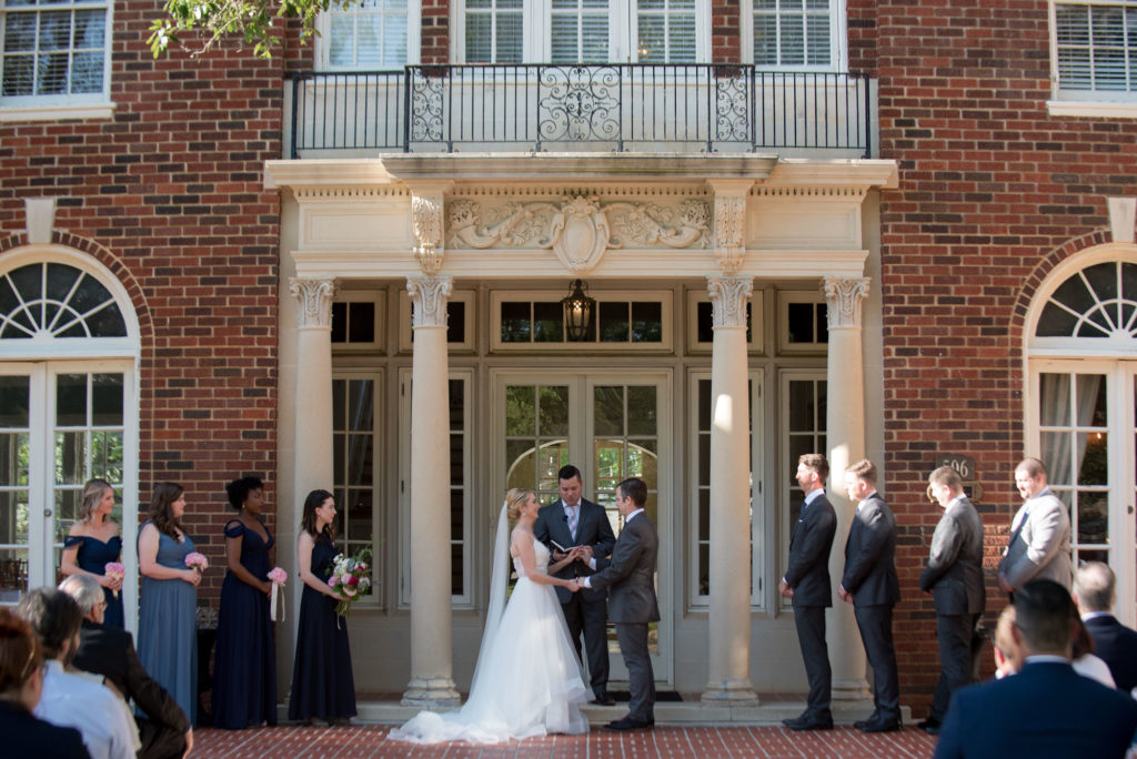 ceremony in front of the Astin Mansion columns outdoors