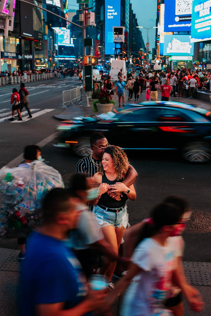New York City couple in busy city streets of Time Square for photoshoot