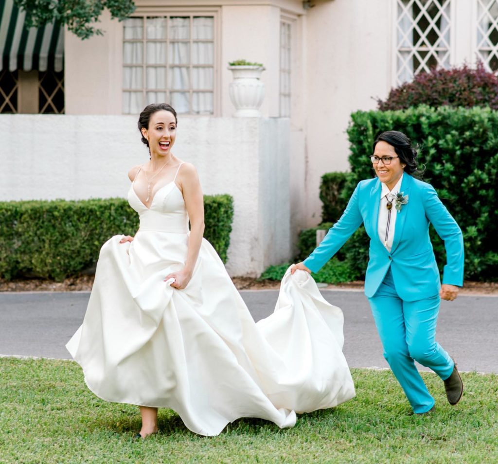 LGBTQ Wedding houston brides running with turquoise suit