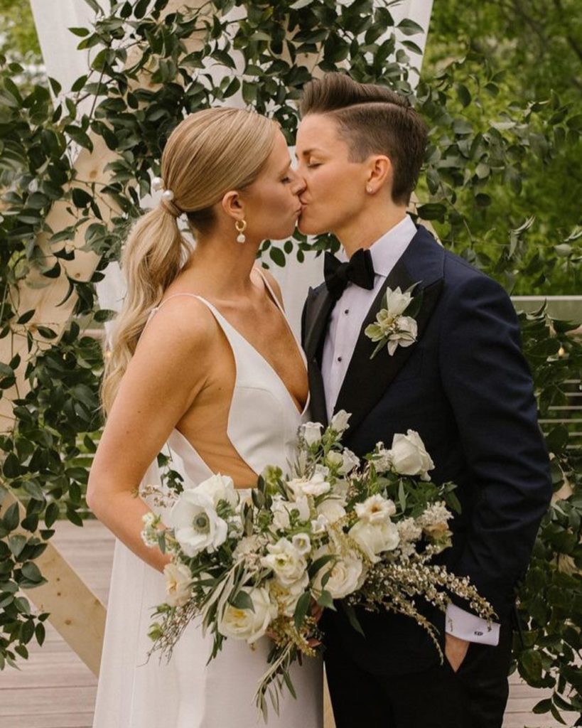 LGBTQ luxury Wedding Houston brides kiss in white dress and black suit 